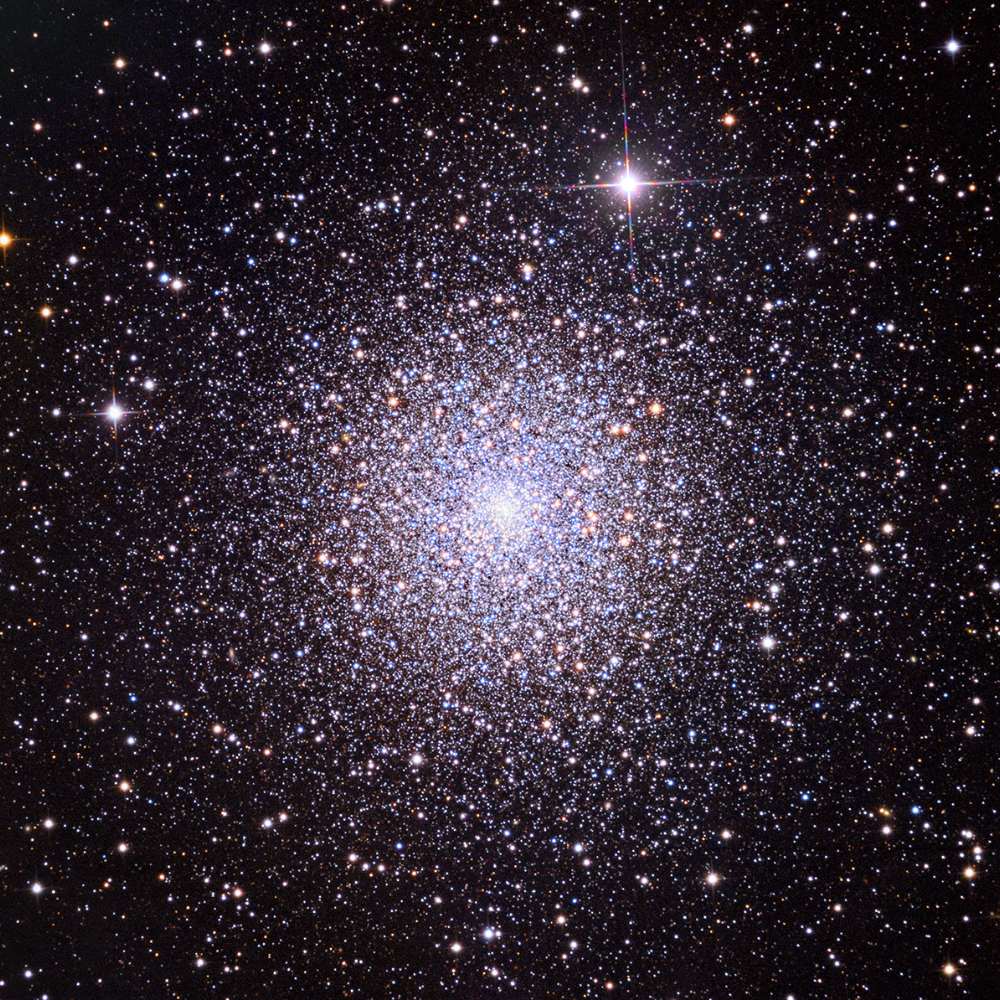 High-resolution image of the Pegasus Cluster showing a densely packed globular core surrounded by thousands of stars, revealing the structure and luminosity of this star-rich galaxy cluster.