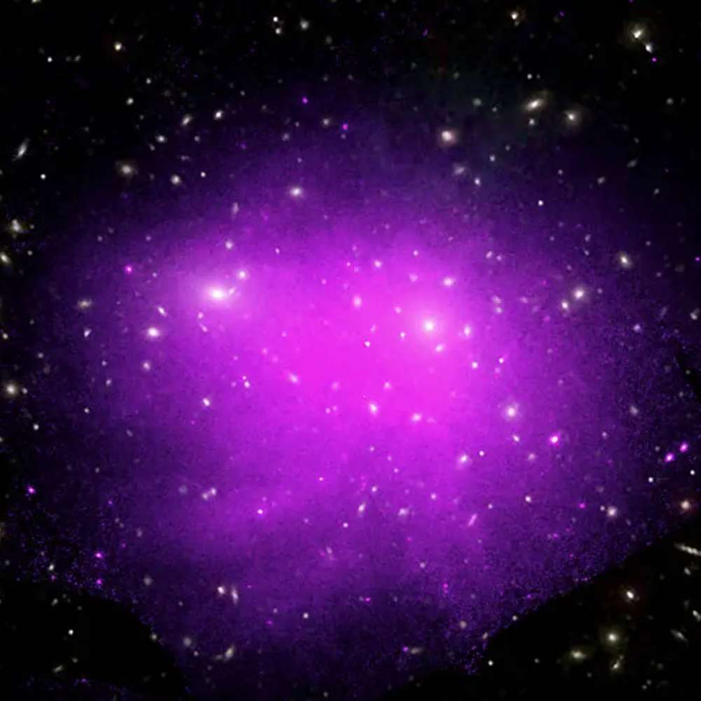 Composite image of the Coma Cluster showing galaxies in optical light and hot gas in X-ray emission, revealing the dense core of this rich galaxy cluster.