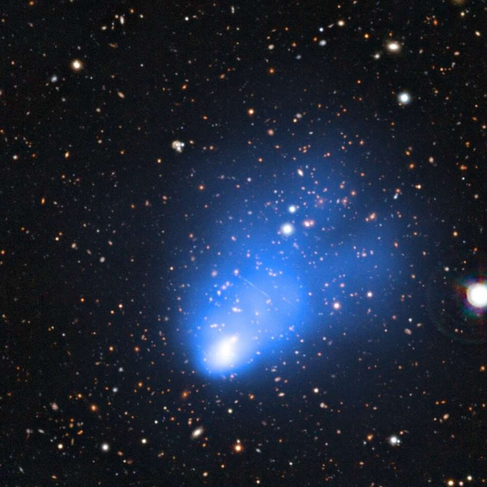 Composite image of El Gordo galaxy cluster, showing hot gas in blue through X-ray emission and distant galaxies in optical view, revealing a massive merging system in the early universe.