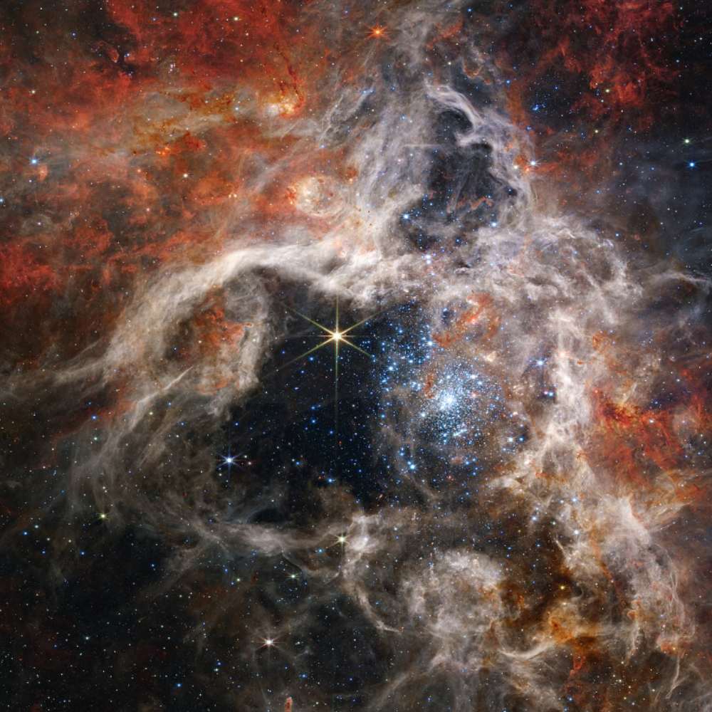 High-resolution image of the Tarantula Nebula showing bright star clusters and intricate filaments of gas and dust in vivid colors.