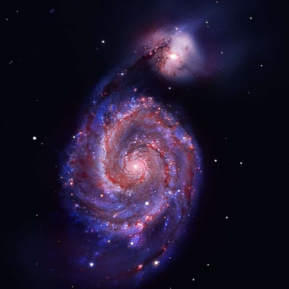 Image of the Whirlpool Galaxy (M51) showing its vivid spiral structure and interacting companion galaxy, highlighting star formation and gravitational effects.