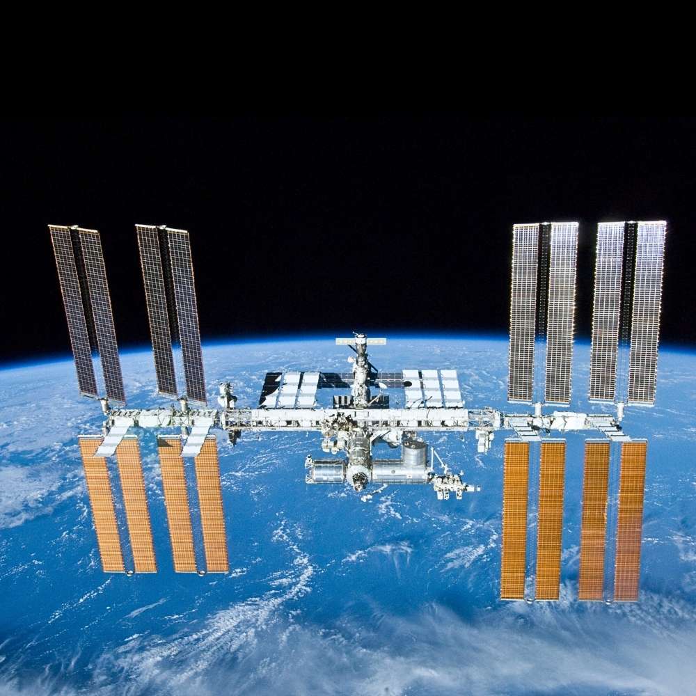International Space Station orbiting Earth with solar arrays, serving as a microgravity research laboratory