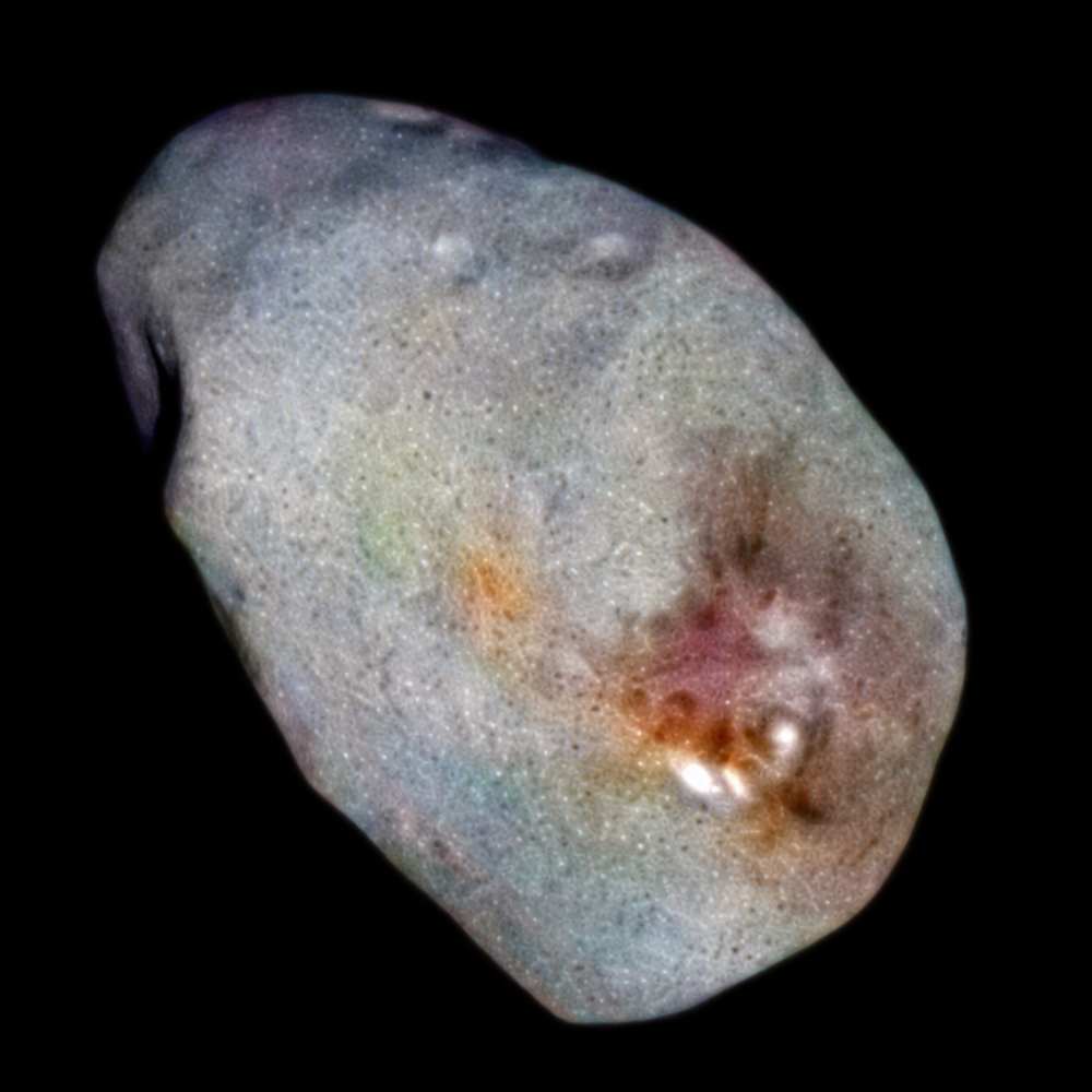 Irregularly shaped moon Nix orbiting Pluto, showing a multicolored icy surface with impact features revealed by New Horizons imaging.