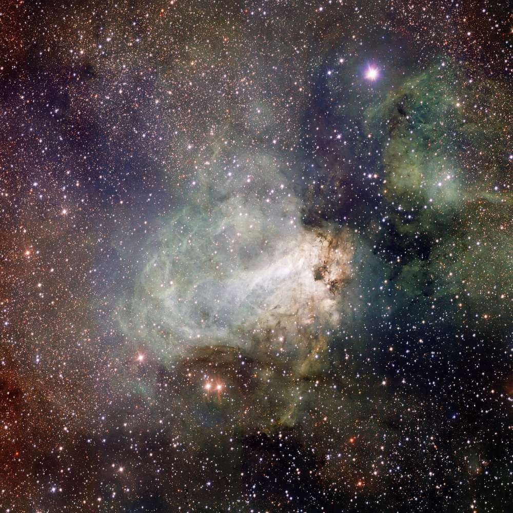 Deep-space image of the Omega Nebula (M17), showing bright star-forming clouds, glowing gas, and dense dust structures within the Sagittarius region.