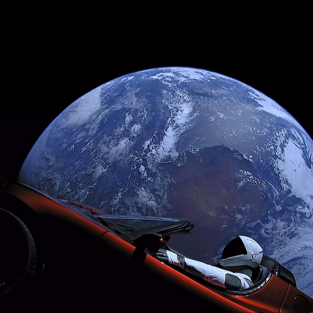 Elon Musk’s Tesla Roadster drifting through space with Earth in the background after launch aboard SpaceX Falcon Heavy.